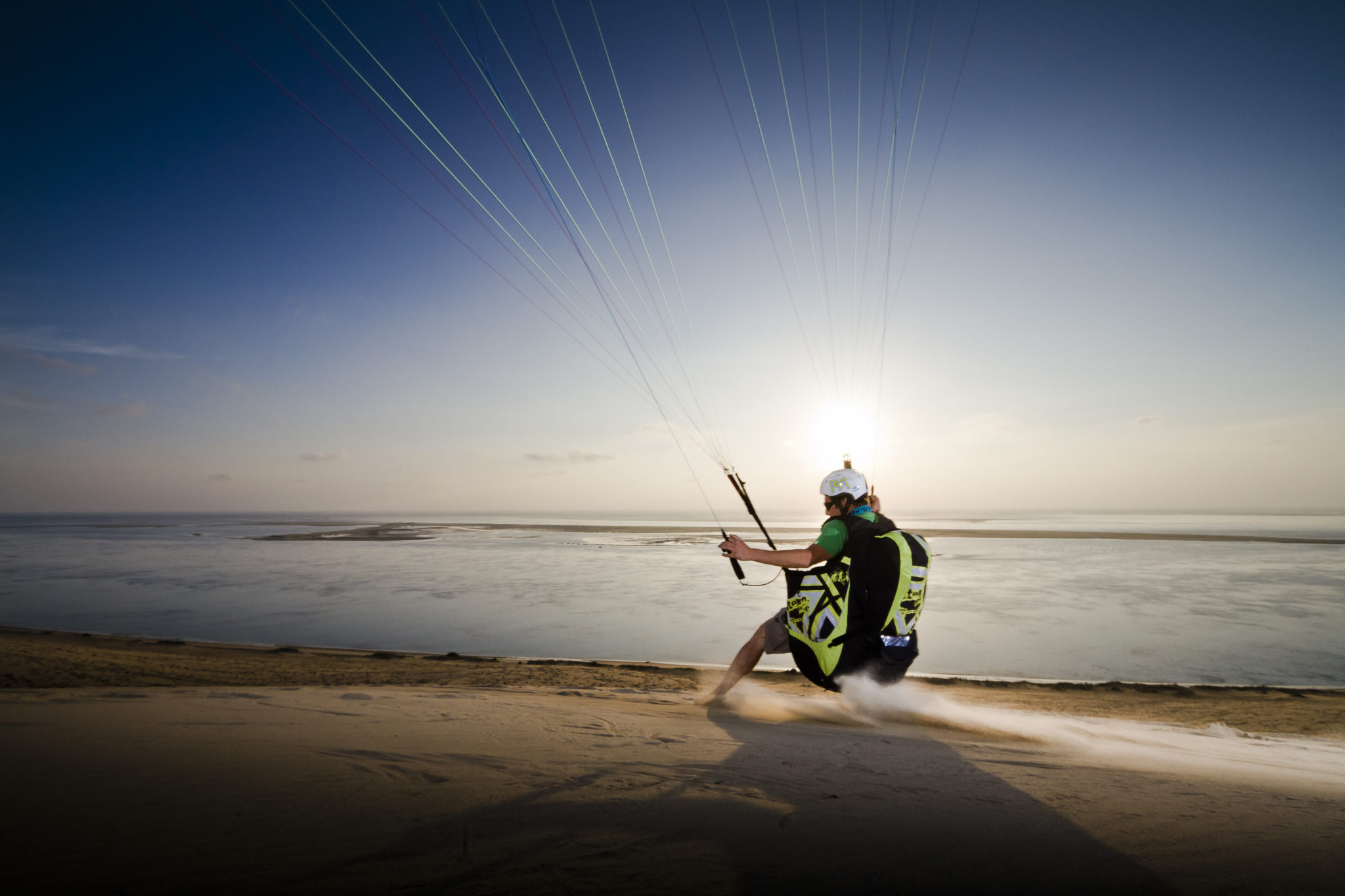 Un parapentiste en train d'atterrir sur la dune du Pilat.